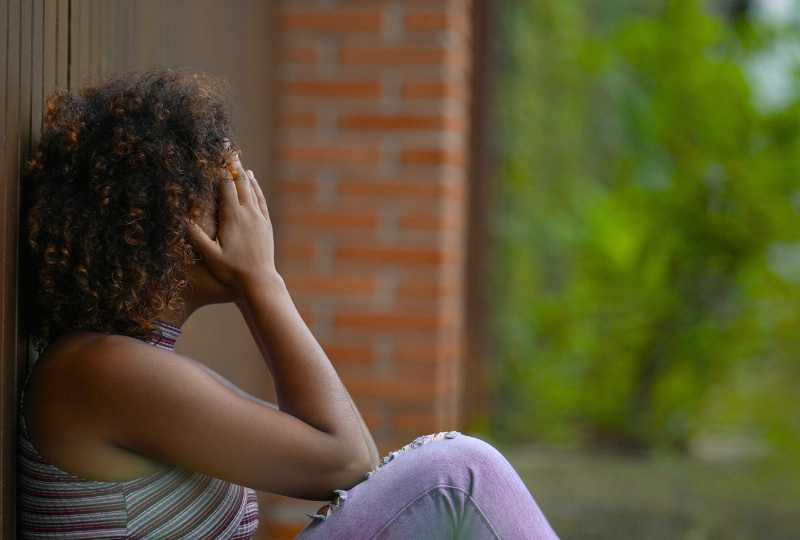 A girl holds her head in shame from sexual abuse